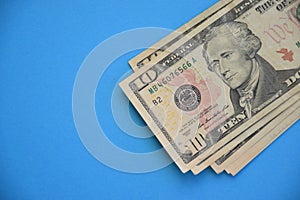 Bundle of ten dollar bills banknotes on blue background