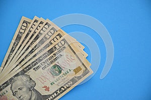 Bundle of ten dollar bills banknotes on blue background