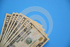 Bundle of ten dollar bills banknotes on blue background