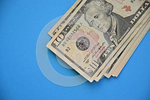 Bundle of ten dollar bills banknotes on blue background
