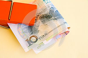 A bundle of Yuan or renminbi notes in an orange clip