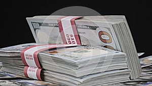 Bundles of Dollars Lying on a Pile of Money and Rotate on Black Background