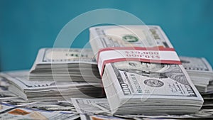 Bundles of Dollars Lying on a Pile of Money and Rotate on blue Background