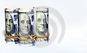 Bundles of money rolls of dollars  on white background, stack of one hundred dollars American cash money bills rolled up