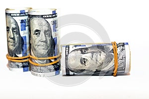 Bundles of money rolls of dollars  on white background, stack of one hundred dollars American cash money bills rolled up