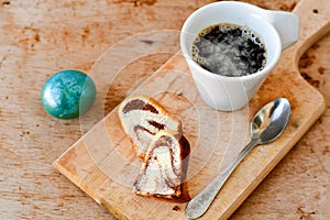 Bundt easter marble cake, blue easter egg and cup of coffee