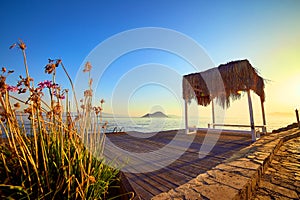 Bungalow on the sea at sunset. Wooden pavilions on the shore of a sandy beach - Bodrum, Turkey