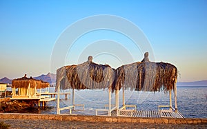 Bungalow on the sea at sunset. Wooden pavilions on the shore of a sandy beach - Bodrum, Turkey