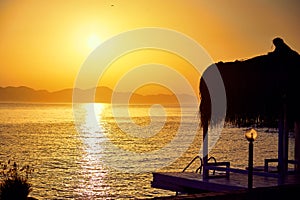 Bungalow on the sea at sunset. Wooden pavilions on the shore of a sandy beach - Bodrum, Turkey