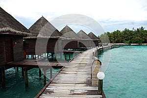 Bungalow and timber pier at island resort Maldives