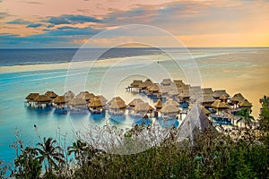 bungalows over idyllic beach at sunset, Moorea, French Polynesia, Tahiti