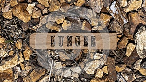 Bungee written on wooden surface. Background stone pattern created