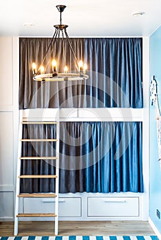 Bunk bed for boyd with blue gray curtains in the bedroom without people