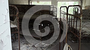 Bunk beds inside an abandoned kindergarten in Pripyat ghost town. Old rusty soviet beds in kindergarten. Chernobyl