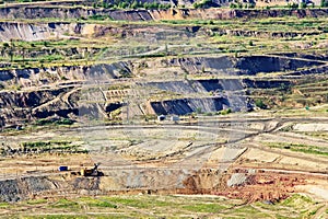 Bunk wall surface mine with exposed colored minerals and brown coal, view from above