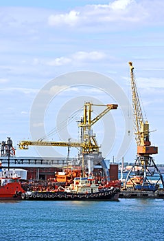 Bunker ship and tugboat under port crane