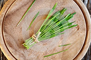 A bunle of fresh green barley grass on a wooden table