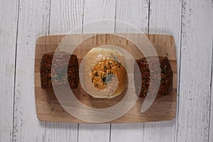 Buns of bread on cutting board isolated on white wooden background flat lay