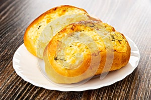 Buns with cheese and garlic in plate on wooden table