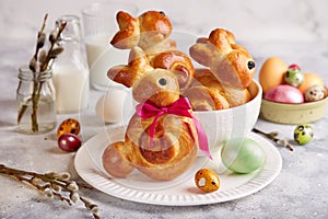 Buns made from yeast dough in a shape of Easter bunny, and colored eggs
