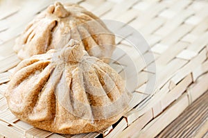 Buns of rye flour lie on a light woven textured background. Homemade cake. Mexican day of dead bread, pan de Muerto