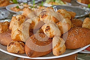 Buns with sesame and other pastries on a plate