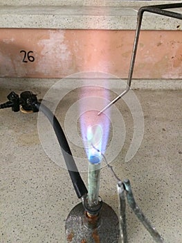 Bunsen burner with copper wire splitting blue flame in half
