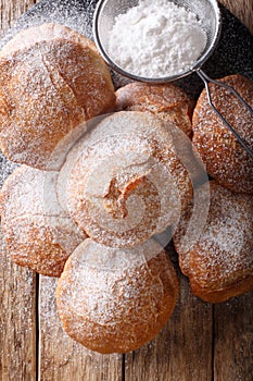 Bunuelos Mexican fritters sprinkled with powdered sugar close-up. Vertical top view