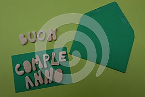 Buon Compleanno, Happy Birthday in italian language composed with handmade wooden letters on a green card photo