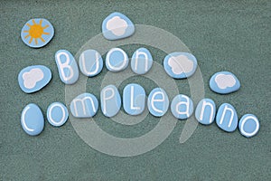 Buon Compleanno, italian Happy Birthday text composed with blue colored stone letters photo