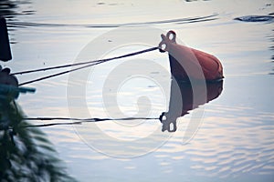 Buoy floating on the water and its reflection casted below it