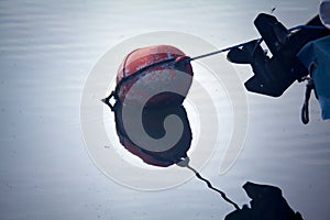 Buoy floating on the water and its reflection casted below it