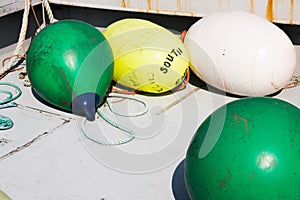 Buoys on boat deck- green, yellow, white