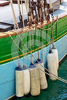 Buoys hanging outside the hull of a colorful wooden sailing boat
