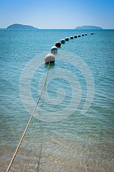 Buoys strung together on beautiful blue sparkling waters and clear sea