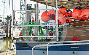 Buoys tied to back side of a fishing boat. Colorful buoys hanging on a fishing boat