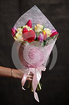 Buquet of various tulips and roses on the dark background