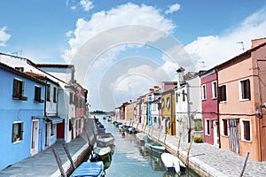 Burano island, Italy - beautiful view of a street with colorful houses and canal. Venice postcard
