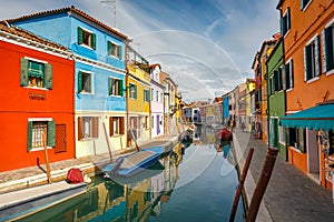 The Burano island near Venice, a canal between colorful houses