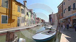 Burano island, people walk along the streets of the canal of the island of Burano. Venice, Italy.