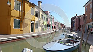 Burano island, people walk along the streets of the canal of the island of Burano. Venice, Italy.