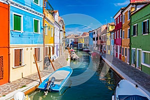 Burano, Italy with colorful painted houses along canal with boats