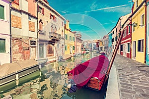 Burano, Italy with colorful painted houses along canal with boats