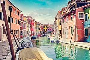 Burano, Italy with colorful painted houses along canal with boats