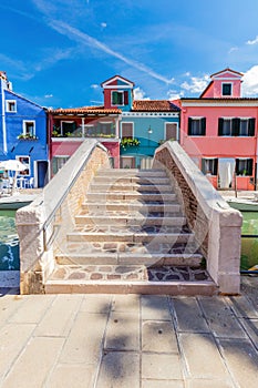 Burano, Italy with colorful painted houses along canal with boats