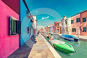 Burano, Italy with colorful painted houses along canal with boats