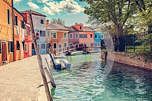 Burano, Italy with colorful painted houses along canal with boats