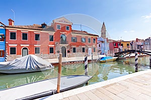 Burano, Italy with colorful painted houses along canal with boats