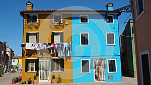 Burano, Venice, Italy. Street with colorful houses with laundry on the facade