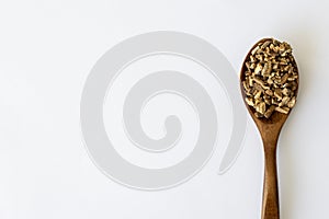 Burdock Root Herb Herbal Medicine. Dried Finely Chopped Root in a Wooden Spoon on a White Background with Copy Space.